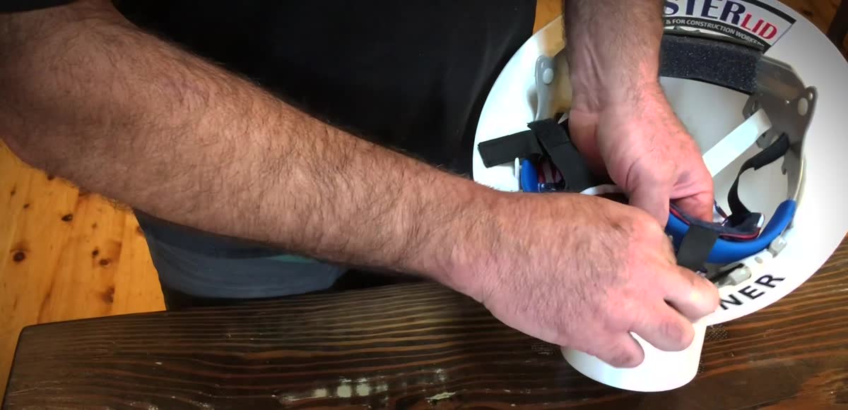 Hands attaching a Lester Lids liner to a hard hat suspension